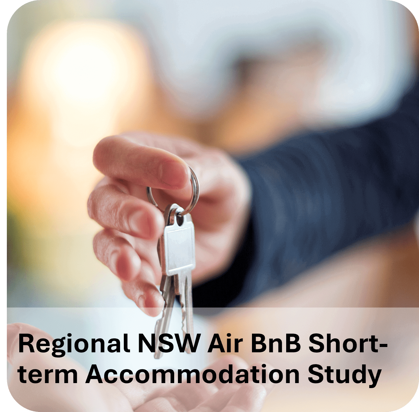 A hand holding a house key with a keychain shaped like a house.