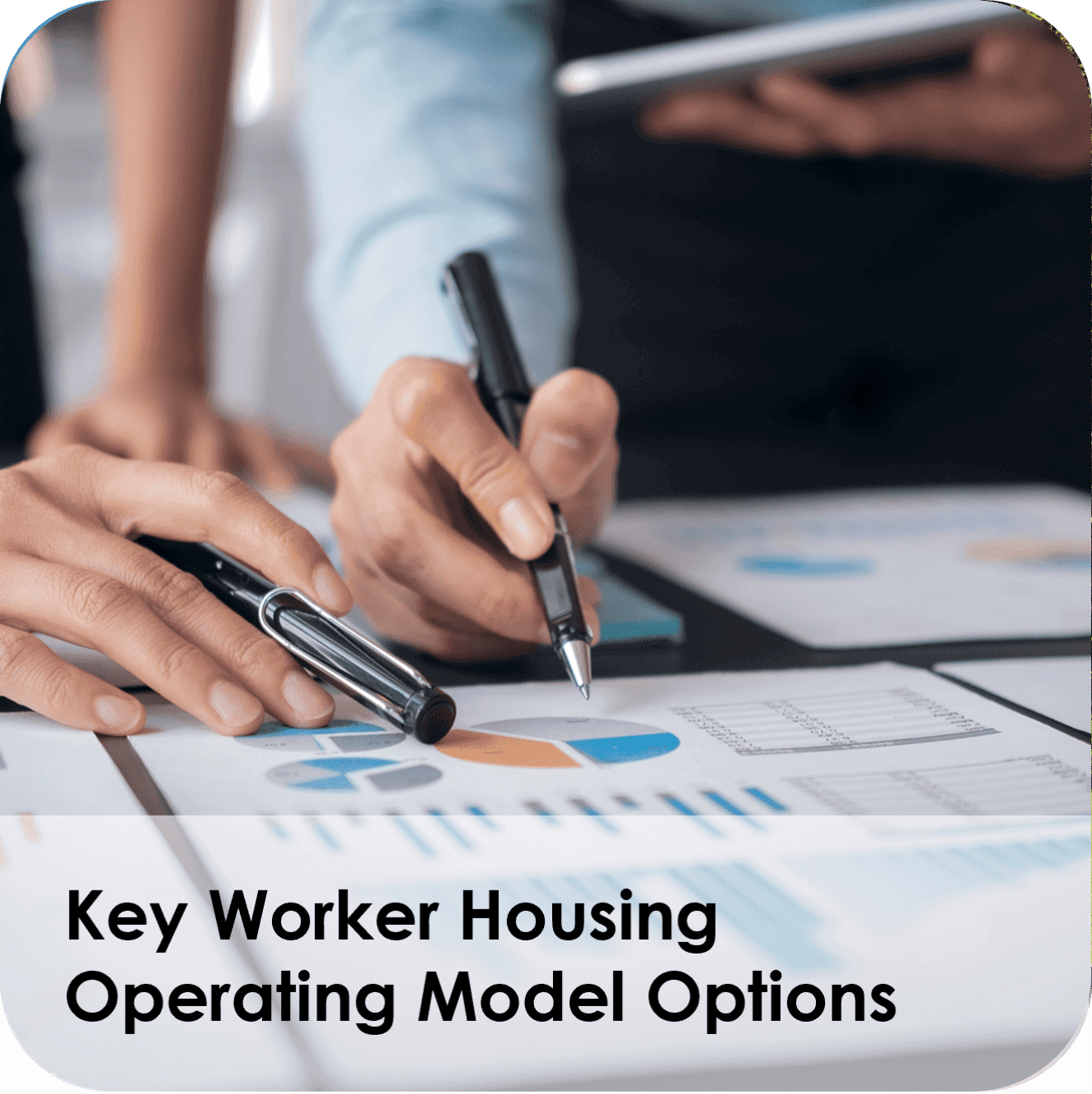 Hands reviewing key worker housing charts