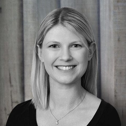 Smiling blonde woman headshot against wooden background