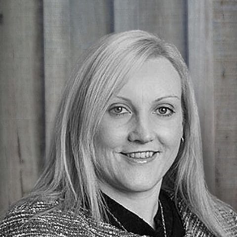Black and white portrait of a smiling woman with light hair.